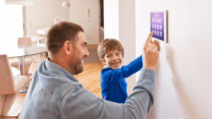 Father and son look at smart home panel