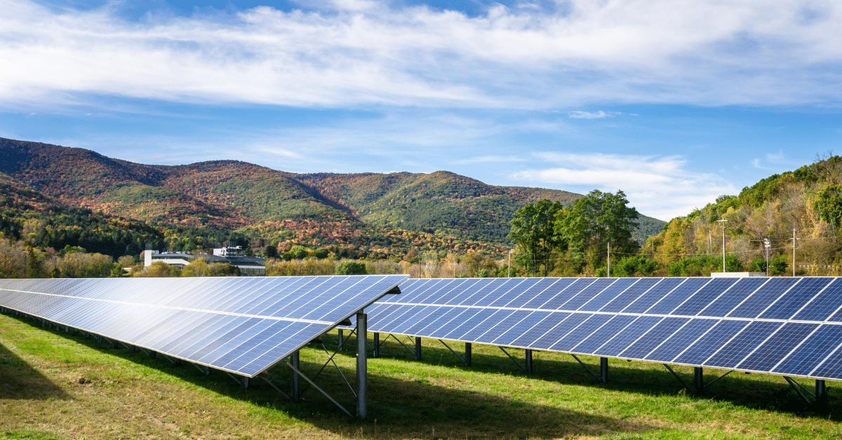 Solar panels in a field with mountains in the background